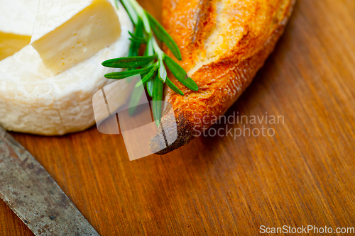 Image of French cheese and fresh  baguette on a wood cutter