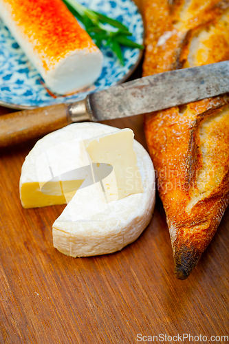 Image of French cheese and fresh  baguette on a wood cutter