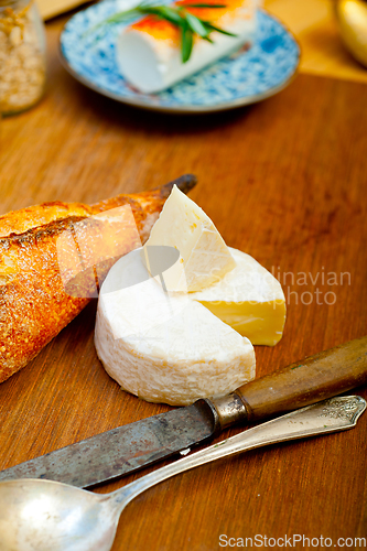 Image of French cheese and fresh  baguette on a wood cutter