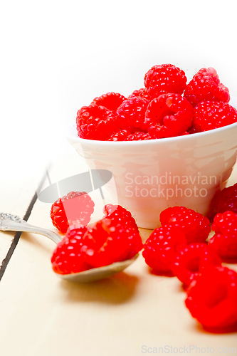 Image of bunch of fresh raspberry on a bowl and white table