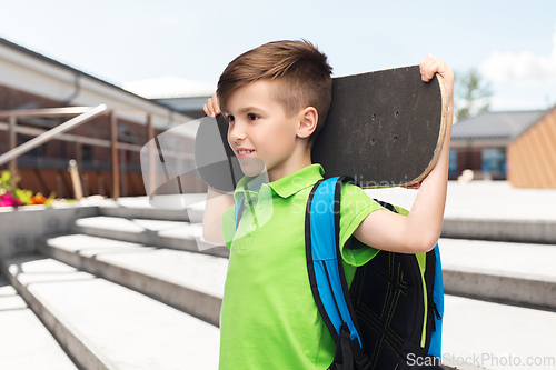 Image of happy student boy with backpack and skateboard