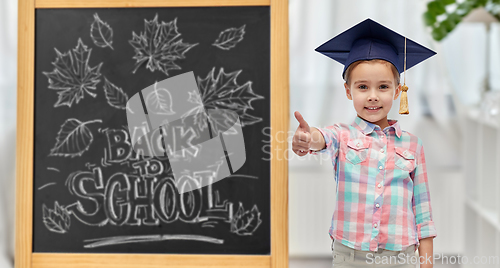 Image of student girl in bachelor hat showing thumbs up