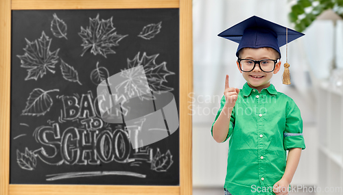 Image of little student boy in bachelor hat and eyeglasses