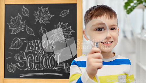 Image of student boy looking through magnifying glass