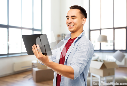 Image of happy young man with tablet computer over new home