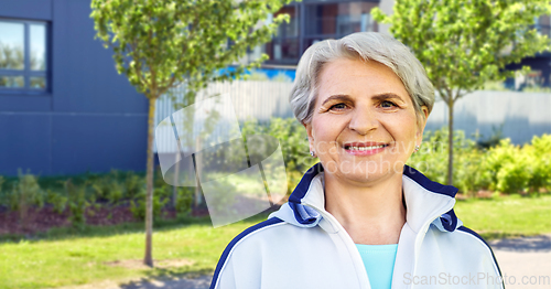 Image of smiling sporty senior woman in city