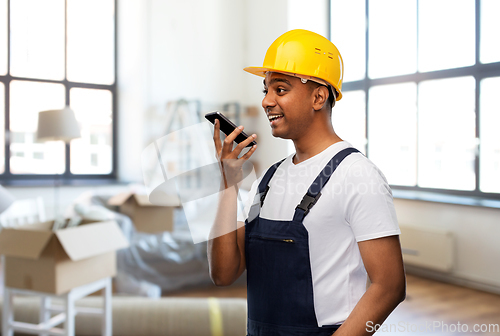 Image of indian worker recording voice on phone at new home