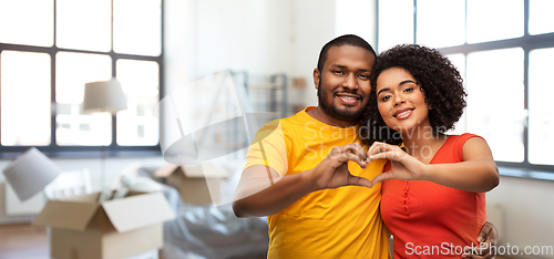 Image of happy couple making hand heart at new home