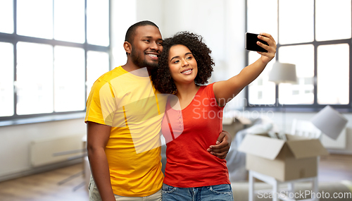 Image of african american couple taking selfie at new home