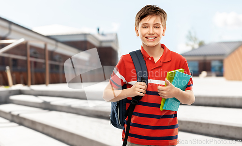 Image of smiling student boy with backpack and books