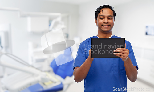 Image of smiling doctor using tablet pc at dental office