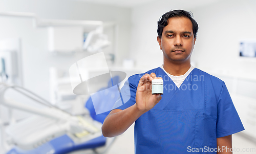 Image of indian doctor holding medicine at dental office