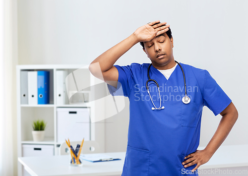 Image of stressed doctor or male nurse in blue uniform