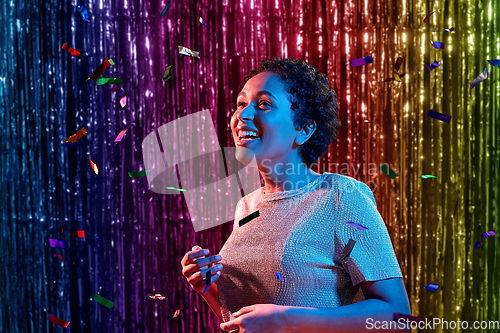 Image of african woman under confetti at nightclub party