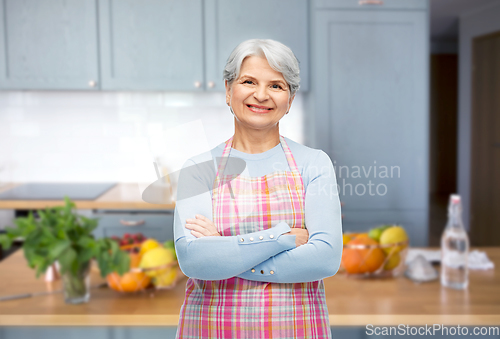 Image of portrait of smiling senior woman at kitchen