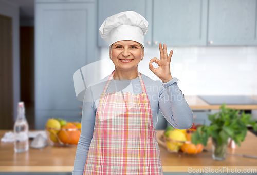 Image of senior woman or chef in toque showing ok hand sign