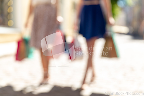 Image of women with shopping bags walking in city