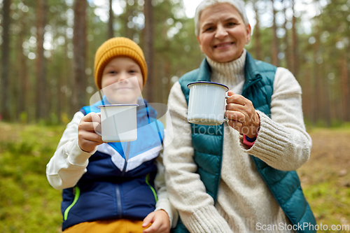 Image of grandmother with grandson drinking tea in forest