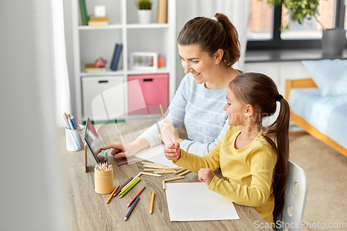 Image of mother and daughter with tablet pc drawing at home