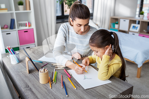 Image of mother with little daughter drawing at home