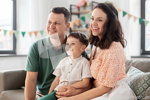 Image of happy family with little son at birthday party