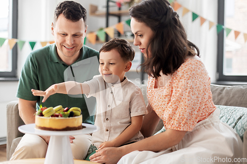 Image of happy family with birthday cake at home