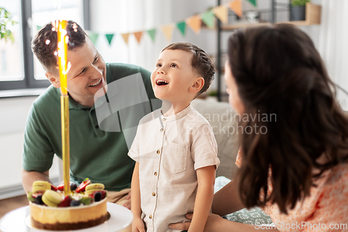 Image of happy family with birthday cake at home