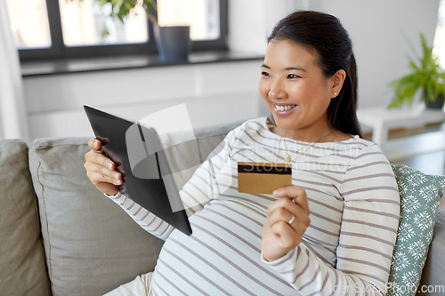 Image of pregnant woman with tablet pc and credit card