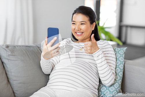 Image of happy pregnant woman having video call on phone