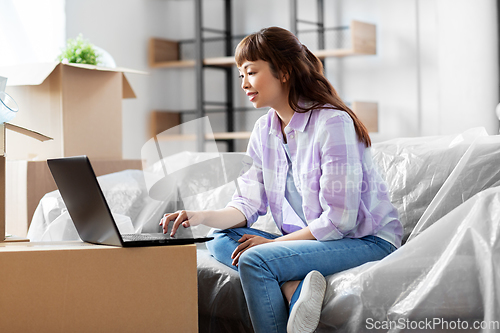 Image of woman with laptop moving into new home