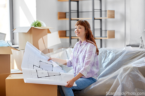 Image of woman with blueprint and boxes moving to new home