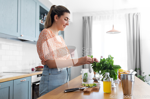 Image of woman making cocktail drinks at home kitchen