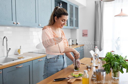 Image of woman making cocktail drinks at home kitchen