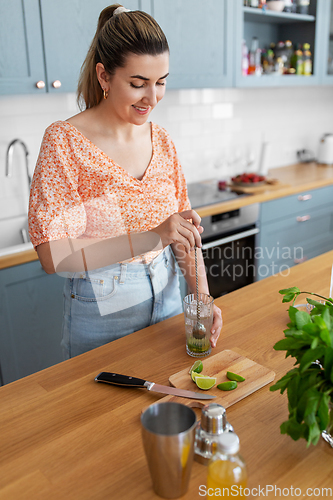 Image of woman making cocktail drinks at home kitchen