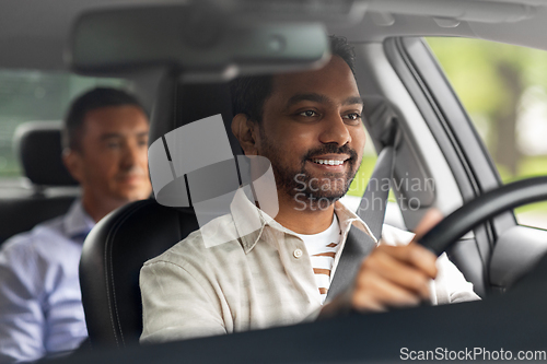 Image of indian male driver driving car with passenger