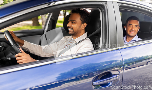 Image of indian male driver driving car with passenger