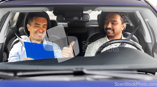 Image of smiling car driving school instructor and driver