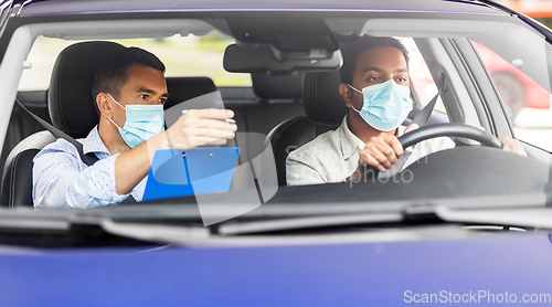 Image of car driving school instructor and driver in mask