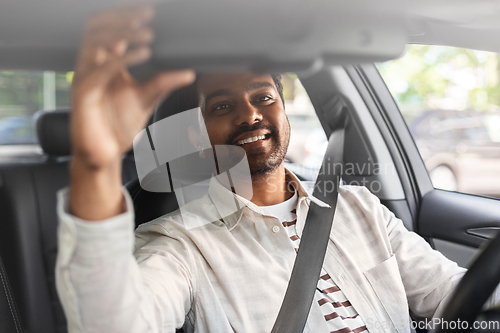 Image of smiling indian man or driver driving car