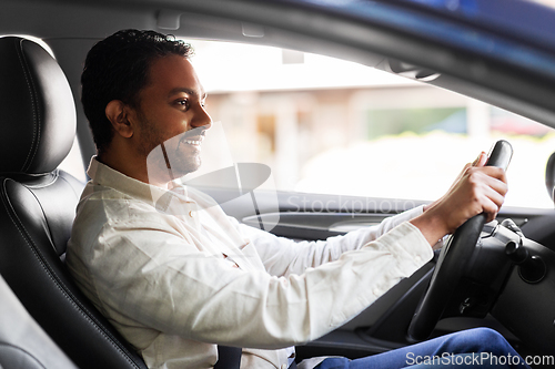 Image of smiling indian man or driver driving car