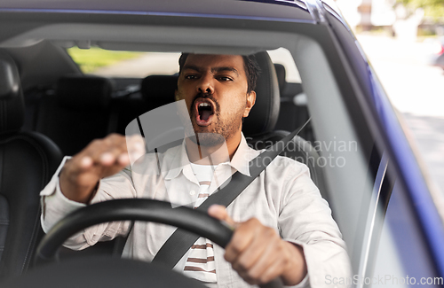 Image of angry indian man or driver driving car
