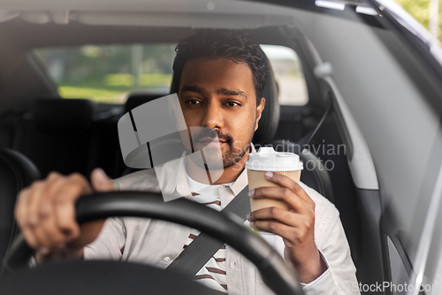 Image of indian man or driver with coffee driving car