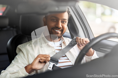 Image of smiling indian man or driver driving car