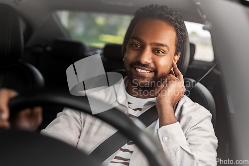 Image of man or driver with wireless earphones driving car