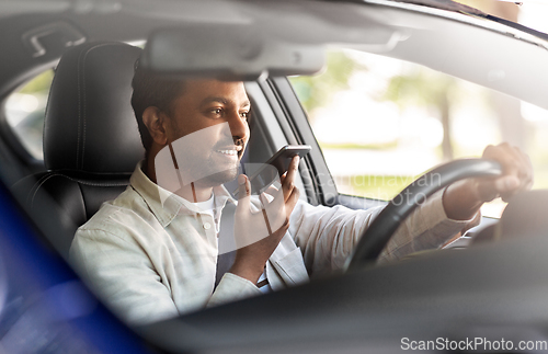 Image of man driving car and recording voice by smartphone