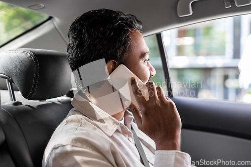 Image of male passenger calling on smartphone in taxi car