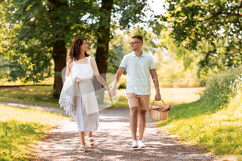 Image of happy couple with picnic basket at summer park