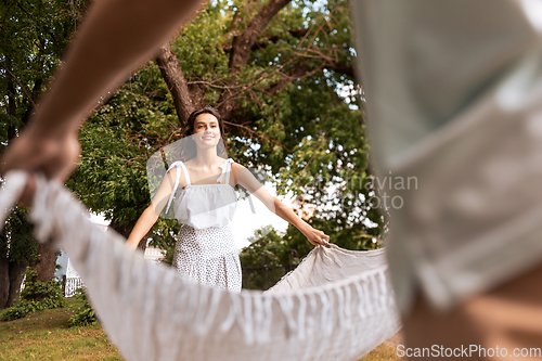 Image of happy couple laying picnic blanket at summer park