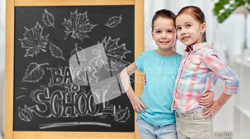 Image of little student girls over school blackboard