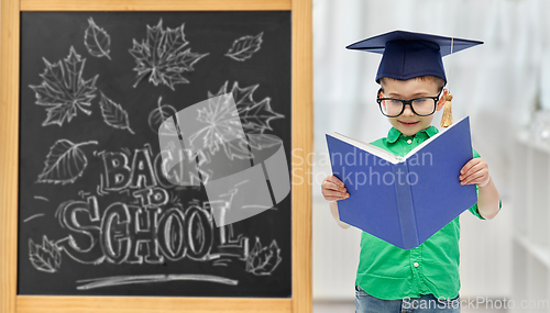 Image of little student boy in bachelor hat and eyeglasses